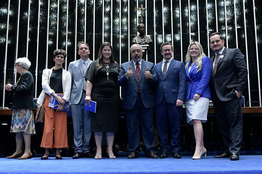Ao término da sessão, senador Paulo Paim (PT-RS) posa para foto com convidados.
