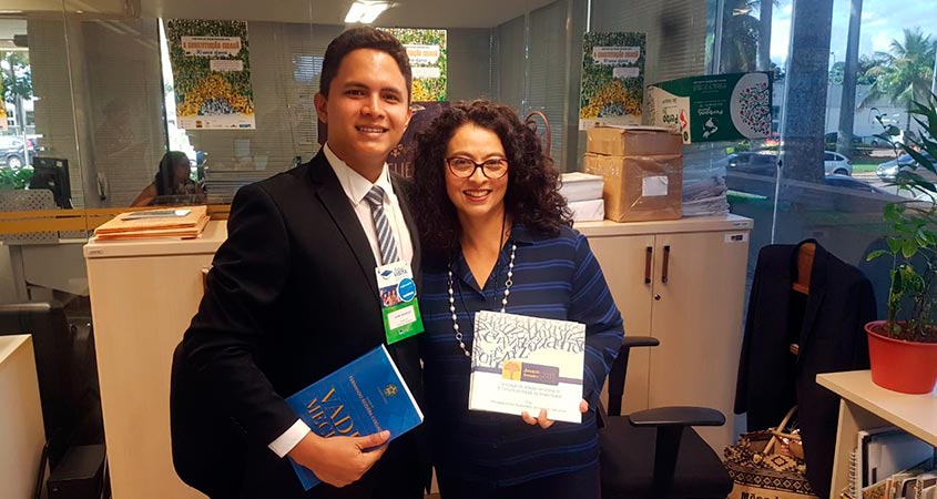 David Williams recebe o kit de divulgação do JS 2018 entregue por Marcia Yukiko da equipe do Jovem Senador