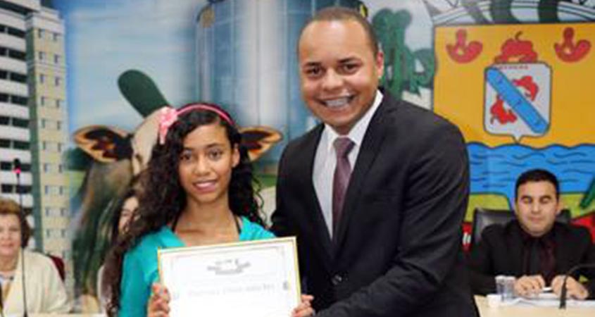 Carlos Henrique entrega o Prêmio Aluno Nota 10 para a aluna Ivanise Santos Silva