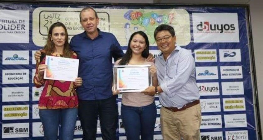O prefeito de Colíder Noboro Tomiyoshi entrega a Moção de Aplausos à Jovem Senadora Larissa e a Professora Cíntia Zocolotto recebe a homenagem do Secretário de Educação Márcio Alves. 