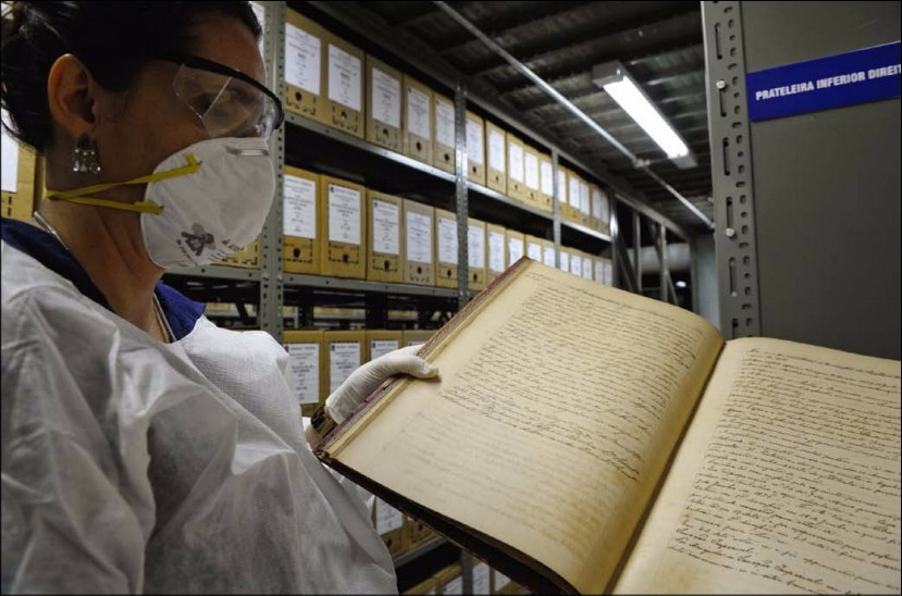 Funcionária do Arquivo do Senado mostra documentos do Império: enfileirados como livros numa estante, papéis cobririam seis vezes a extensão da Avenida Paulista