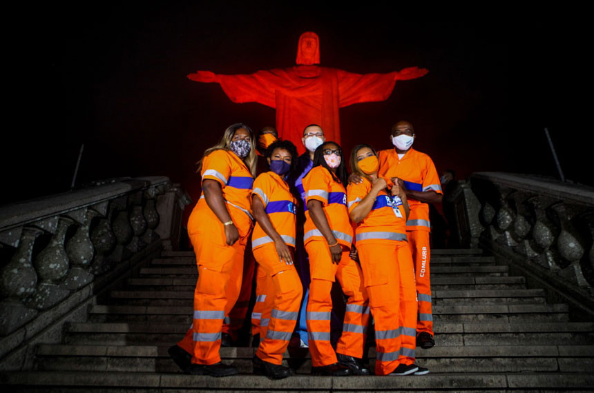 Garis posam em frente à estátua do Cristo iluminada de laranja. Foto: Ricardo Cassiano/Prefeitura do Rio