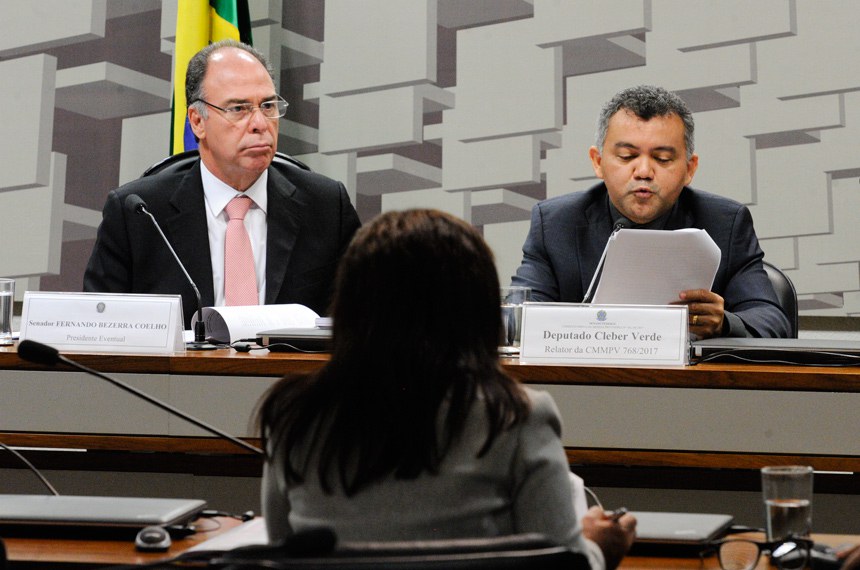 O deputado Cleber Verde (PRB-MA) lê o relatório sobre a Medida Provisória 768/2017, ao lado do senador Fernando Bezerra Coelho (à esq.) que presidia a reunião da comissão mista