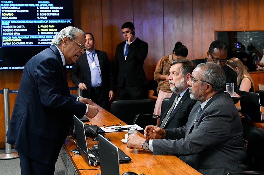 Autor do projeto, o senador Jayme Campos (em pé) conversa com o relator, Paulo Paim (à dir.), e o senador Flávio Arns na reunião da Comissão de Assuntos Sociais que aprovou a proposta