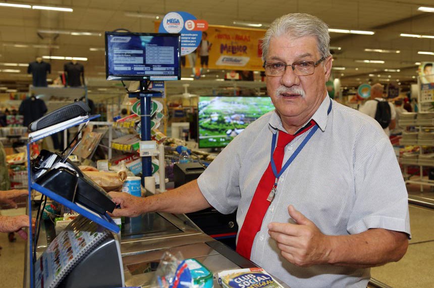 Aposentado Marcos Henrique Ribeiro trabalha como caixa de supermercado em Curitiba.  Agência do Trabalhador - Rendimento dos idosos do Paraná tem maior expansão do Sul e Sudeste.  
