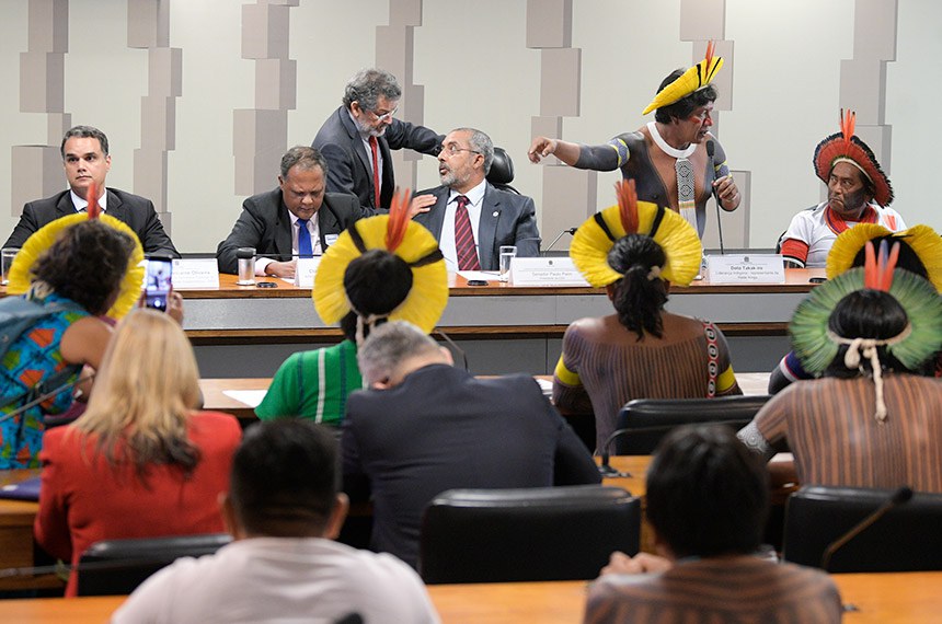 Paulo Rocha (em pé) conversa com o presidente da CDH, Paulo Paim, durante a audiência com representantes dos índios e do governo