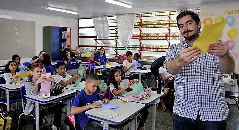 Professor ensina origami a alunos do quarto ano de escola pública de Brasília, em aula sobre conscientização ambiental