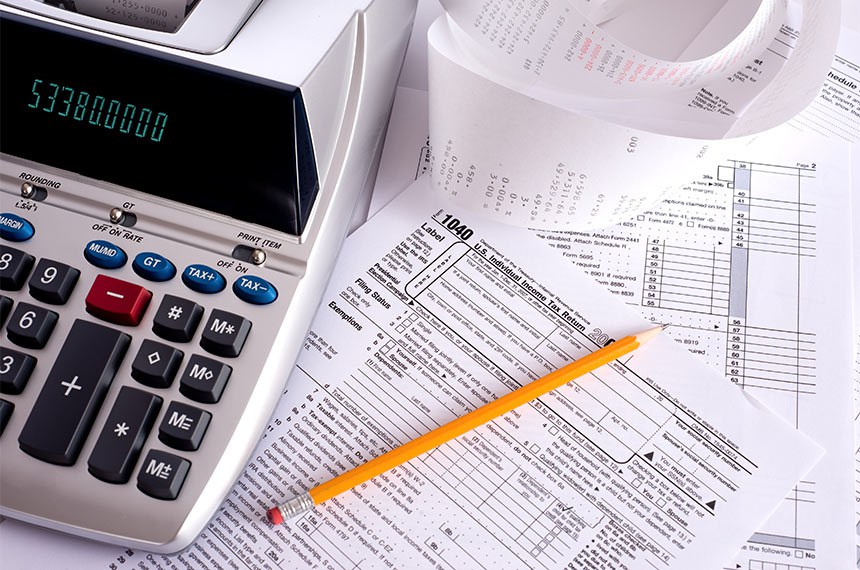 An adding machine or calculator with adding machine tape or paper and tax forms  Notas Fiscais  Foto: Getty Images/iStockphoto