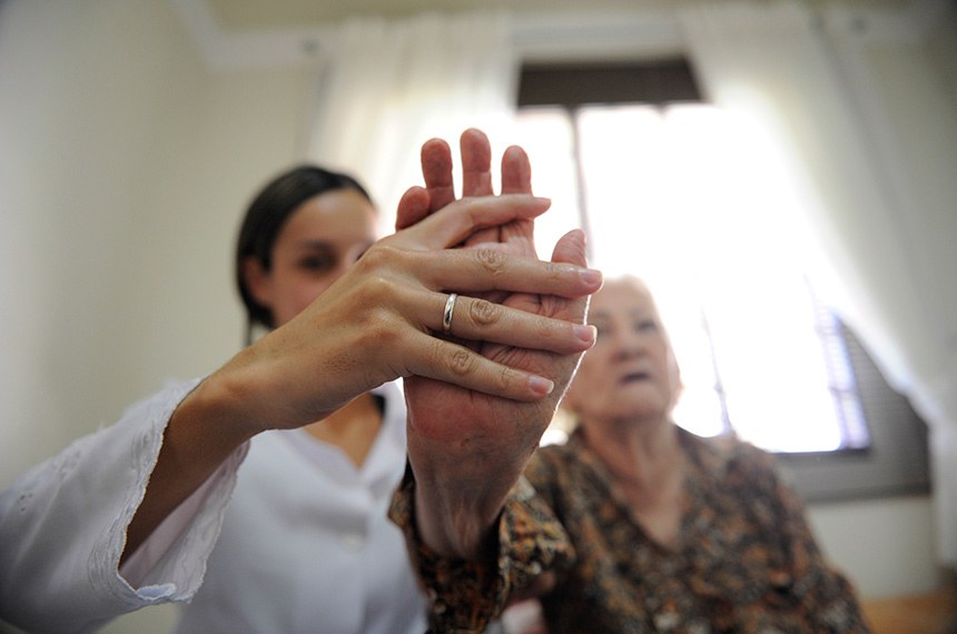 Fisioterapia em casa. Profissionais da saúde cuidam de idosos.