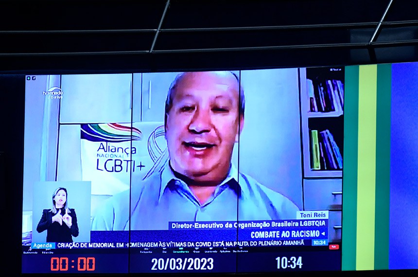 Painel exibe diretor-executivo da organização brasileira LGBTQIA+ chamada Grupo Dignidade, Toni Reis, em pronunciamento via videoconferência.