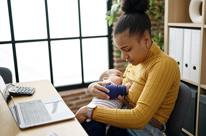Mãe amamenta bebê enquanto trabalha. Amamentação no escritório, empresa, trabalho