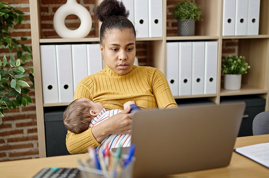 Mãe amamenta bebê enquanto trabalha. Amamentação no escritório, empresa, trabalho