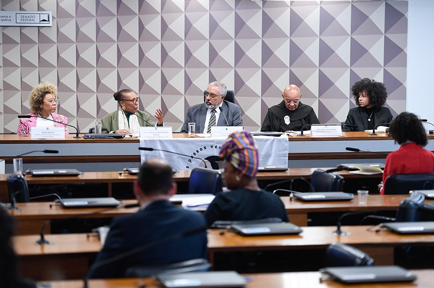 Sobre a mesa, faixa com os seguintes dizeres: " Nossos passos vem de longe".