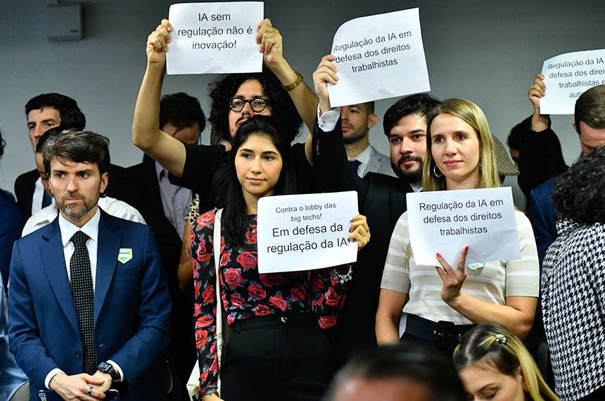 Manifestantes exibem cartazes a favor da regulação da Inteligência Artificial.