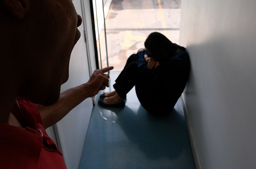 Imagem ilustrativa com o fundo embaçado simula mulher sendo vítima de violência.