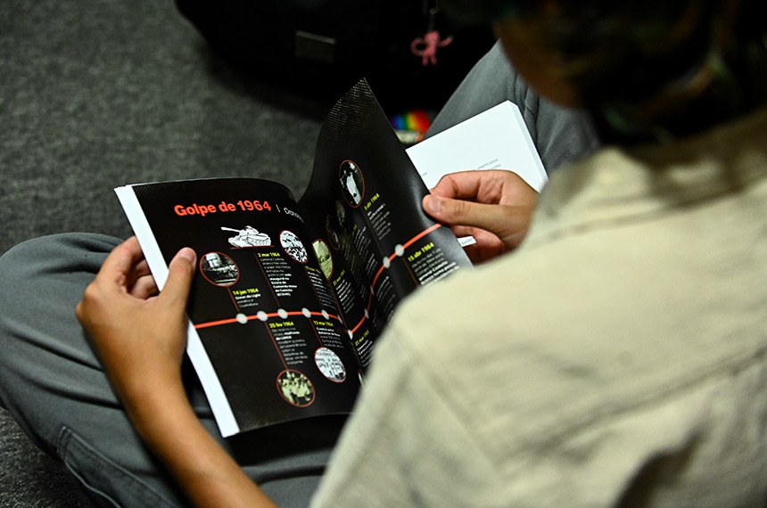 Convidado folheando revista "golpe 1964".