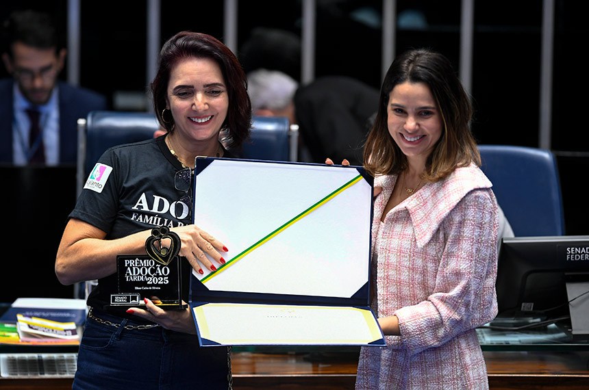 Presidente do Instituto Assembleia de Carinho (IAC) do Estado da Bahia, Tanisia Cunha, procede à entrega do diploma à presidente do Grupo Acalanto Fortaleza, que atua desde 2013 promovendo a cultura da adoção com apoio psicológico e jurídico às famílias, Eliane Carlos de Oliveira.