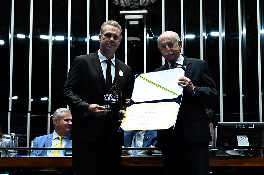 Desembargador do Tribunal de Justiça do Estado da Bahia (TJBA), Salomão Resedá entrega diploma ao pai solo que adotou quatro irmãos, Alexandre Caetano Rank.