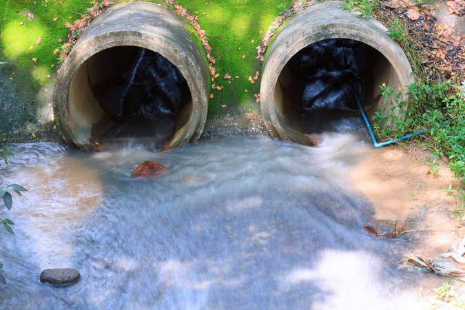 Water flowing out of two concrete drain pipes