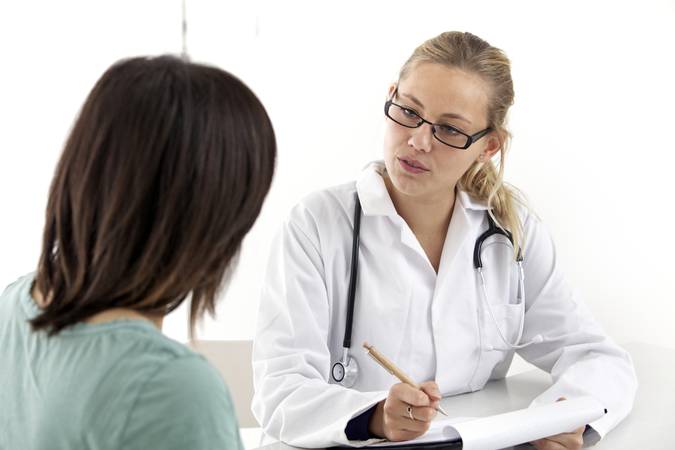 Woman talks to doctor.