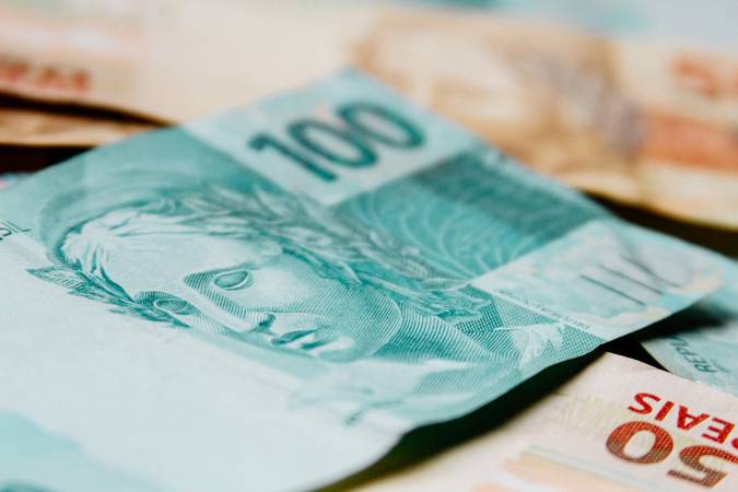Macro closeup of a 100 Brazilian reais banknote on 50 reais notes on background