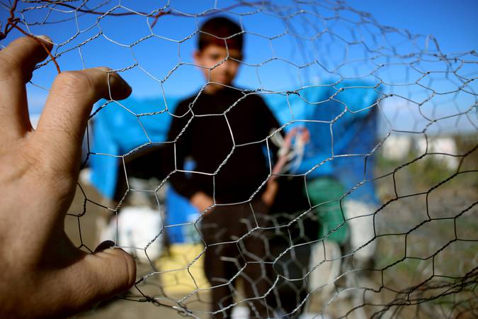 Refugee kid behind wire fence, syria, refugee camp