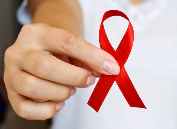 The symbolic conception of the world day of fight against AIDS. The red ribbon in the hands of a young woman.
