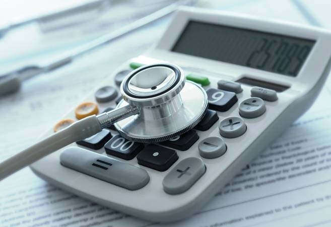 health care costs or medical insurance savings concept. stethoscope on calculator with medical billing.