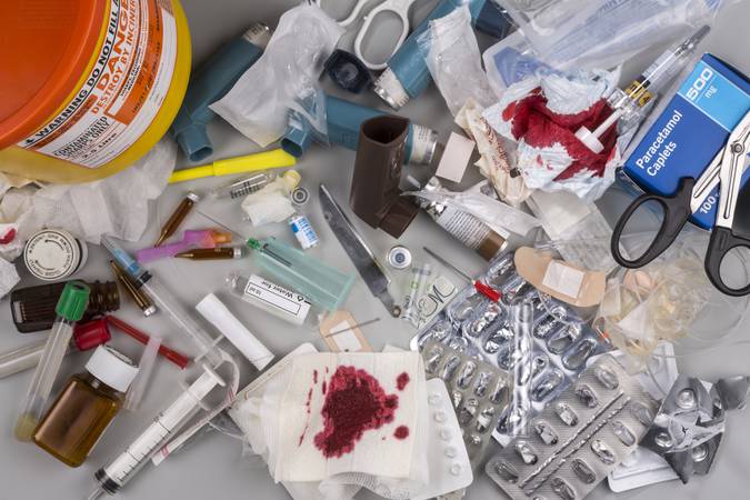 York, United Kingdom - August 10, 2015: Hazardous medical waste that needs to be carefully disposed of by incineration. Items include clinical waste such as used syringes and needles, used swabs, plasters and bandages. Used drug blister packs and ampules. Biomedical waste is potentially infectious.