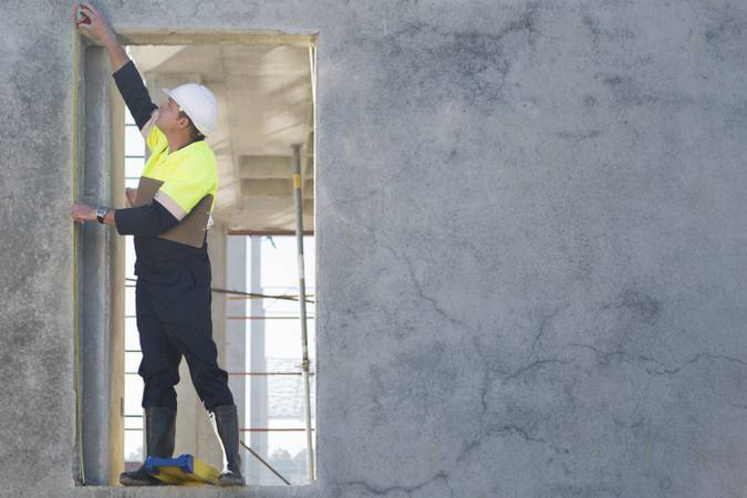 21 Jun 2014 --- Site manager reaching to check doorway on construction site --- Image by © Zero Creatives/Corbis