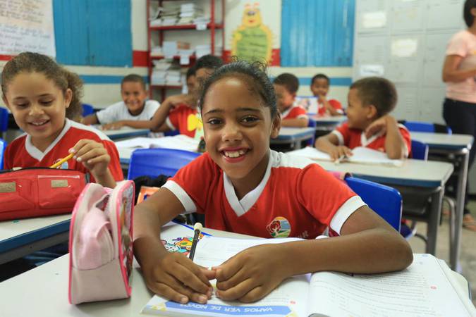 Crianças sorridentes em sala de aula.