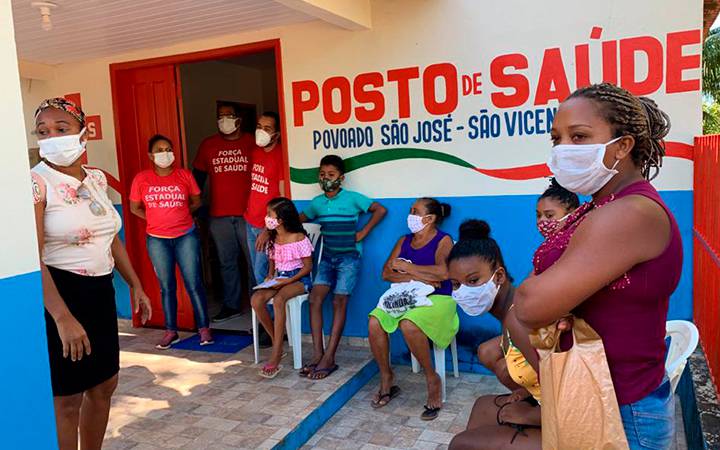 Pessoas do quilombola São Vicente no posto de saúde. Todos usam máscaras.