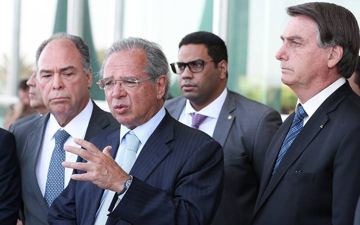 Paulo Guedes, Bolsonaro e senador Fernando Bezerra em coletiva na porta do Planalto. Imagem de arquivo. Ninguém usando máscara, apesar da pandemia.