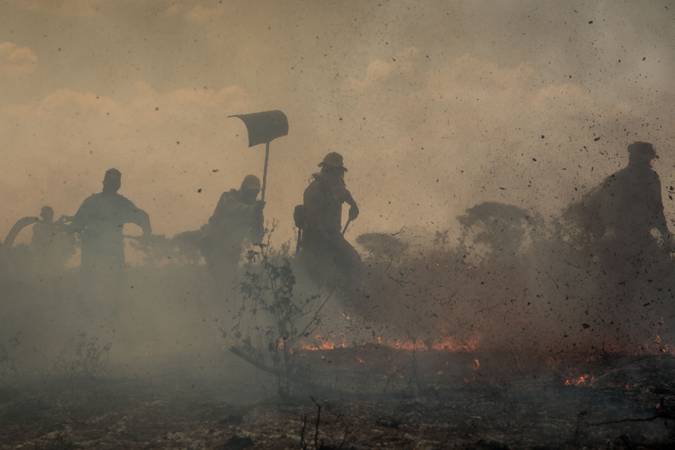 Bombeiros tentam apagar o fogo que consome o Pantanal.